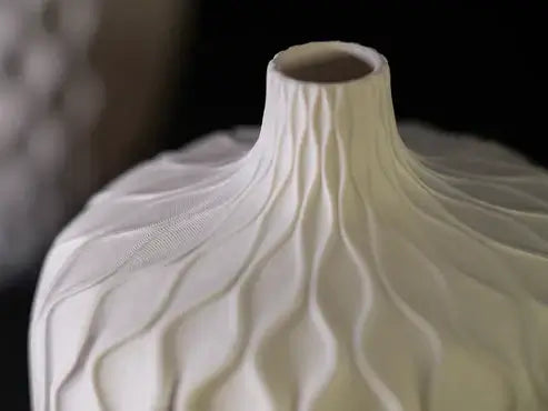 Elegant white wavy vase showcasing unique design and texture for modern home decor.